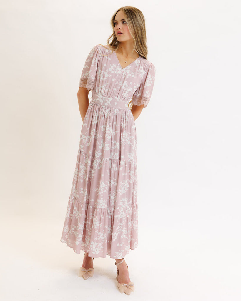 Model wearing a pink floral print short flutter sleeve, v-neck, maxi dress with tiered skirt.