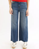 Person wearing blue wide-leg jeans on a white background