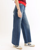 Person wearing blue jeans and a red top on a white background