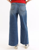 Person wearing blue wide-leg jeans on a white background