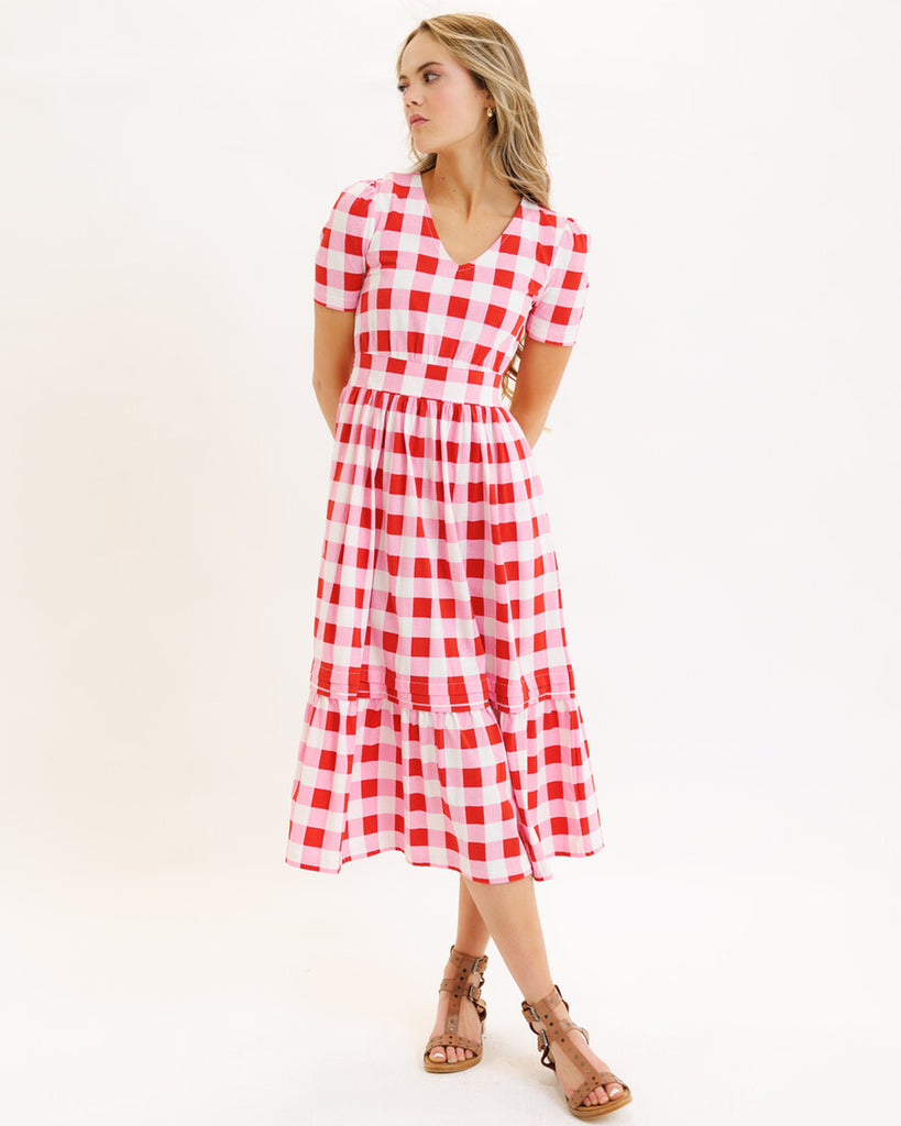 Model wearing a pink checked short sleeve, v-neck midi dress