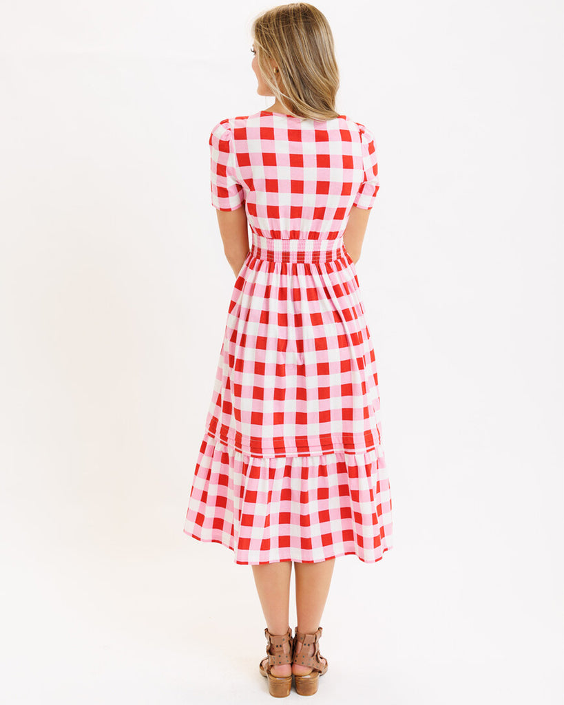 Model wearing a pink checked short sleeve, v-neck midi dress