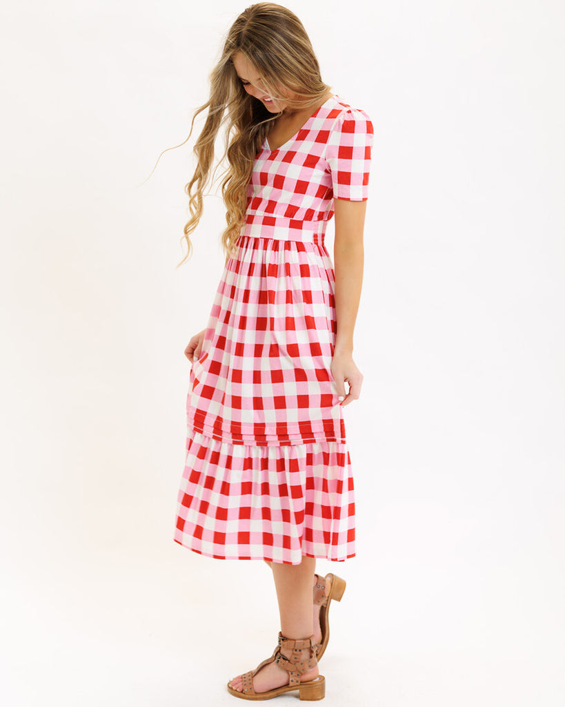 Model wearing a pink checked short sleeve, v-neck midi dress