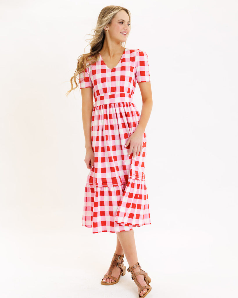 Model wearing a pink checked short sleeve, v-neck midi dress
