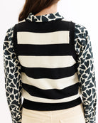 Black and white striped sweater with patterned sleeves on a plain background