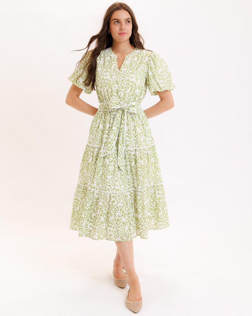 Model wearing a green printed short sleeve v-neck midi dress with a tie at the waist