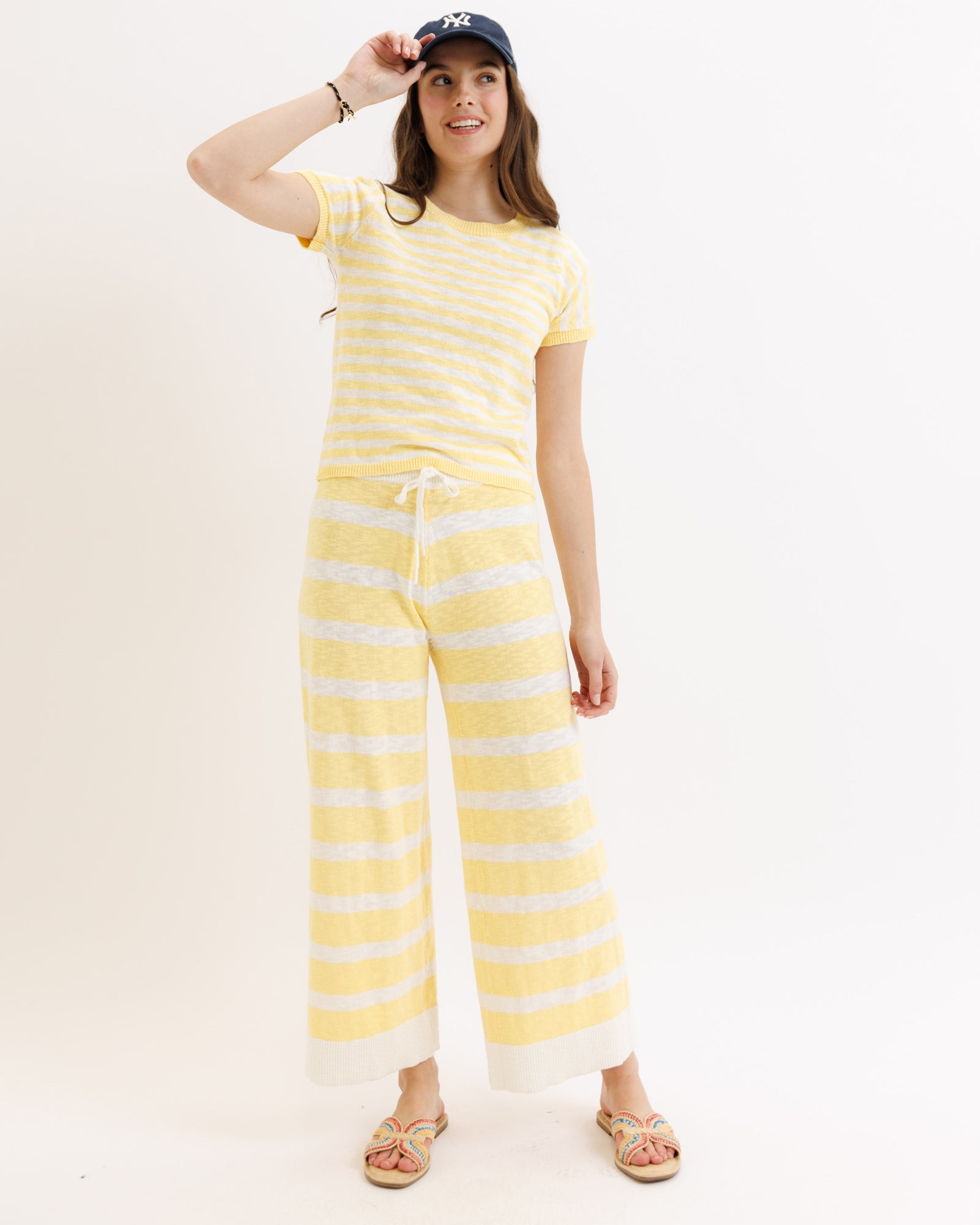 Woman wearing a yellow and white striped outfit on a white background