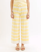 Person wearing yellow and white striped pants on a white background