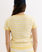 Person wearing a yellow and white striped sweater on a plain background
