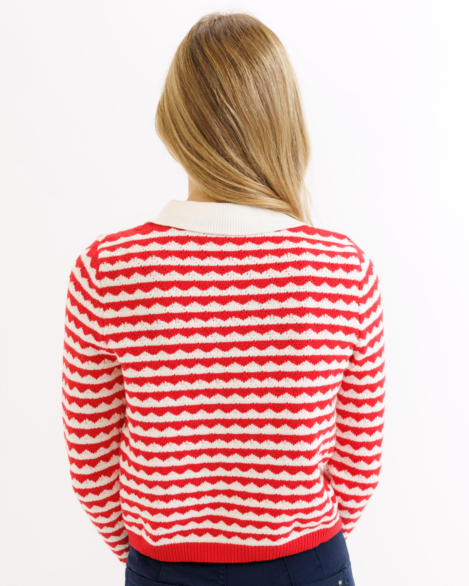 Person wearing a red and white striped sweater on a white background