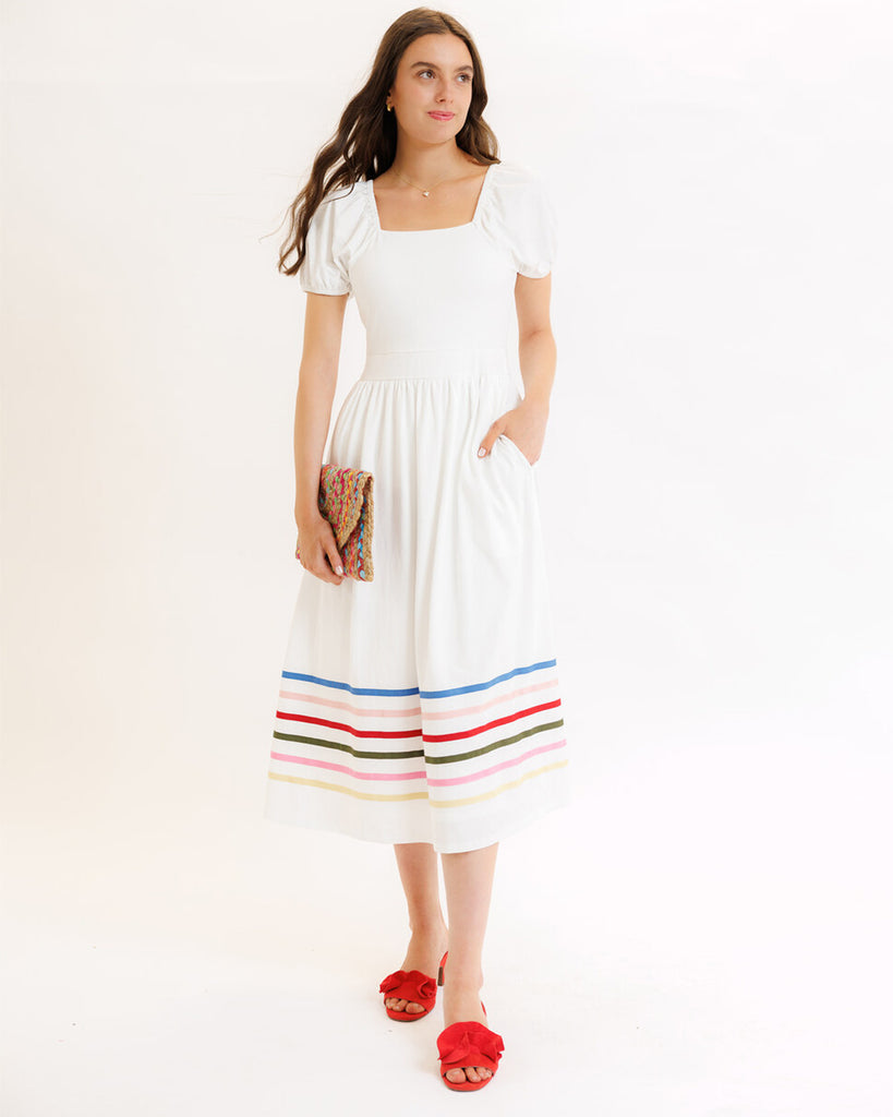 Model wearing a white with rainbow stripes on skirt, short sleeve, square neck, midi dress.