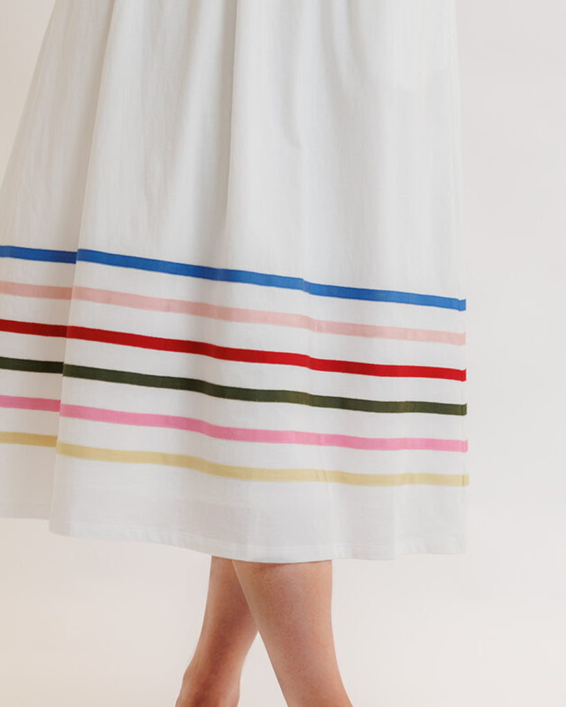 Model wearing a white with rainbow stripes on skirt, short sleeve, square neck, midi dress.