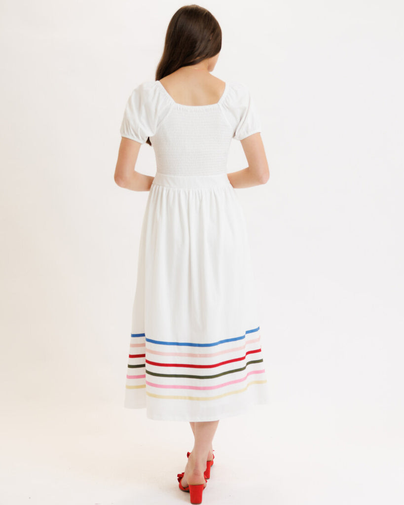 Model wearing a white with rainbow stripes on skirt, short sleeve, square neck, midi dress.