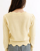 Light yellow sweater worn by a person on a white background