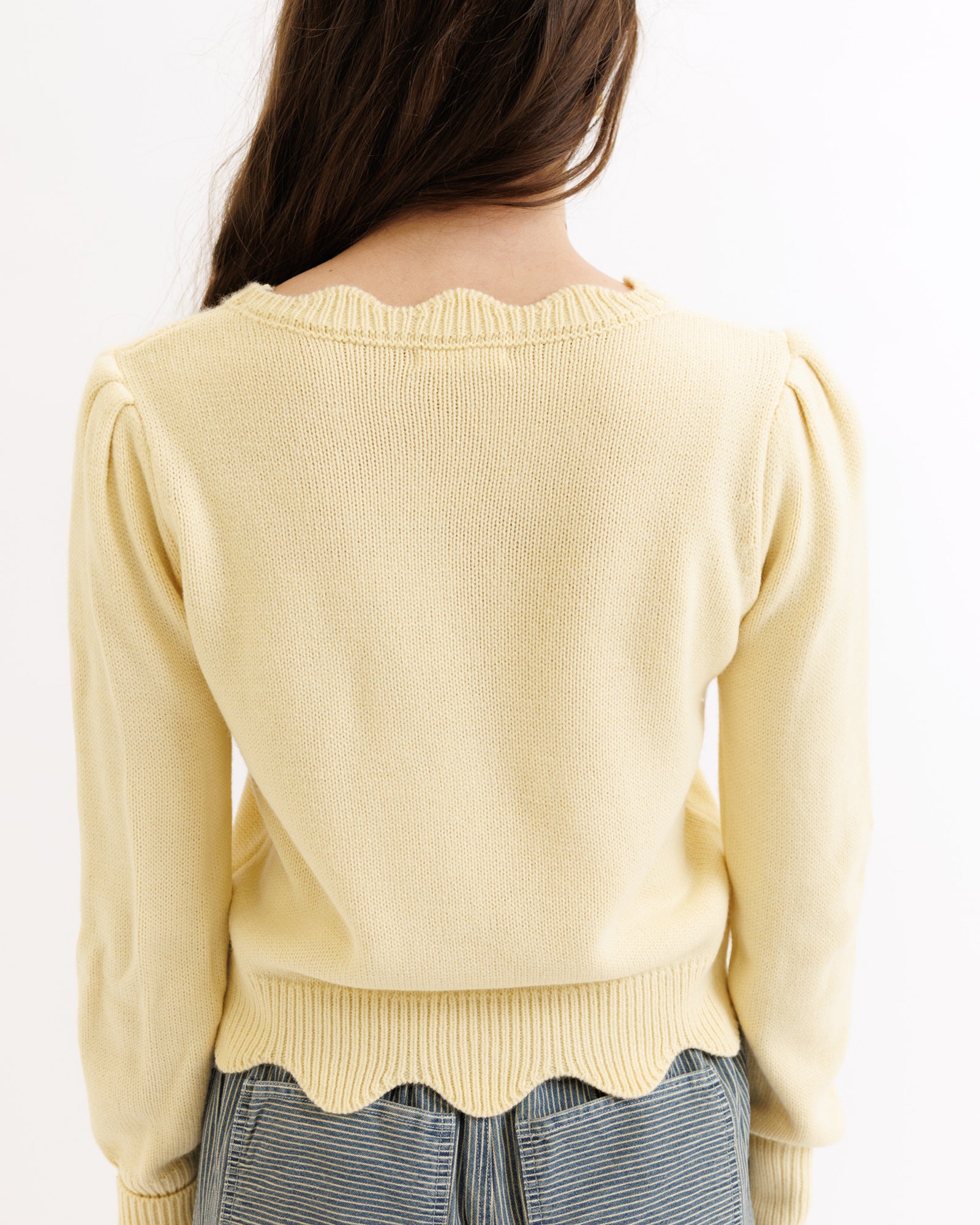 Light yellow sweater worn by a person on a white background