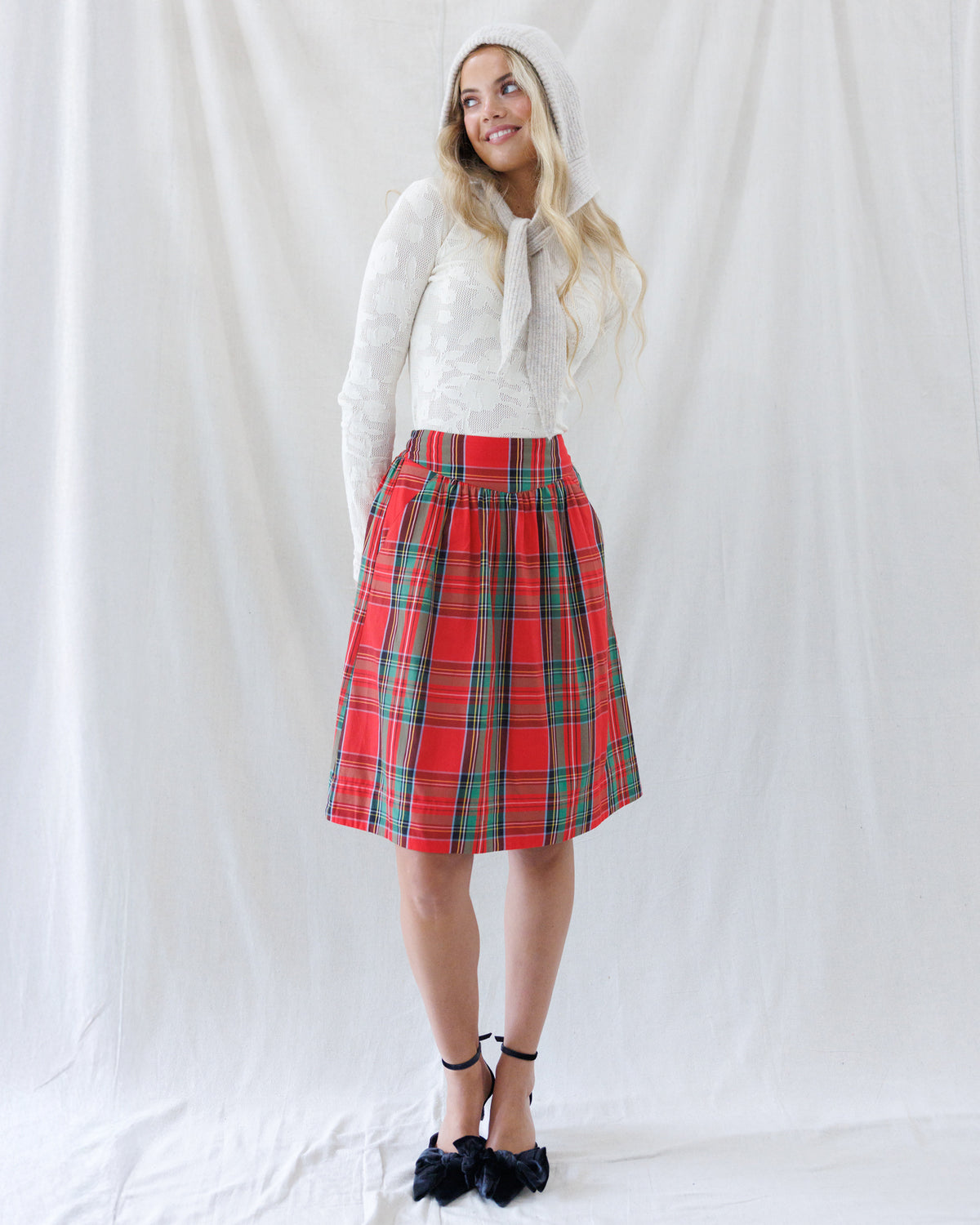 Full-length styled look featuring the fitted ivory textured knit top paired with a red plaid gathered skirt and knit hood scarf.
