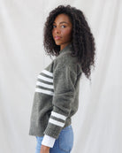 Side profile showing the relaxed drop-shoulder silhouette, side hem coverage, and matching double white athletic stripes along the lower sleeves.