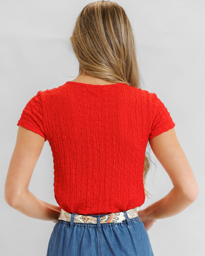 Model wearing a red textured short sleeve tee