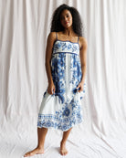 Woman wearing a blue floral dress against a white background
