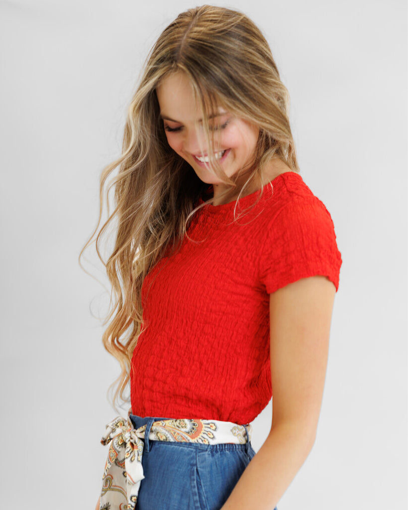 Model wearing a red textured short sleeve tee