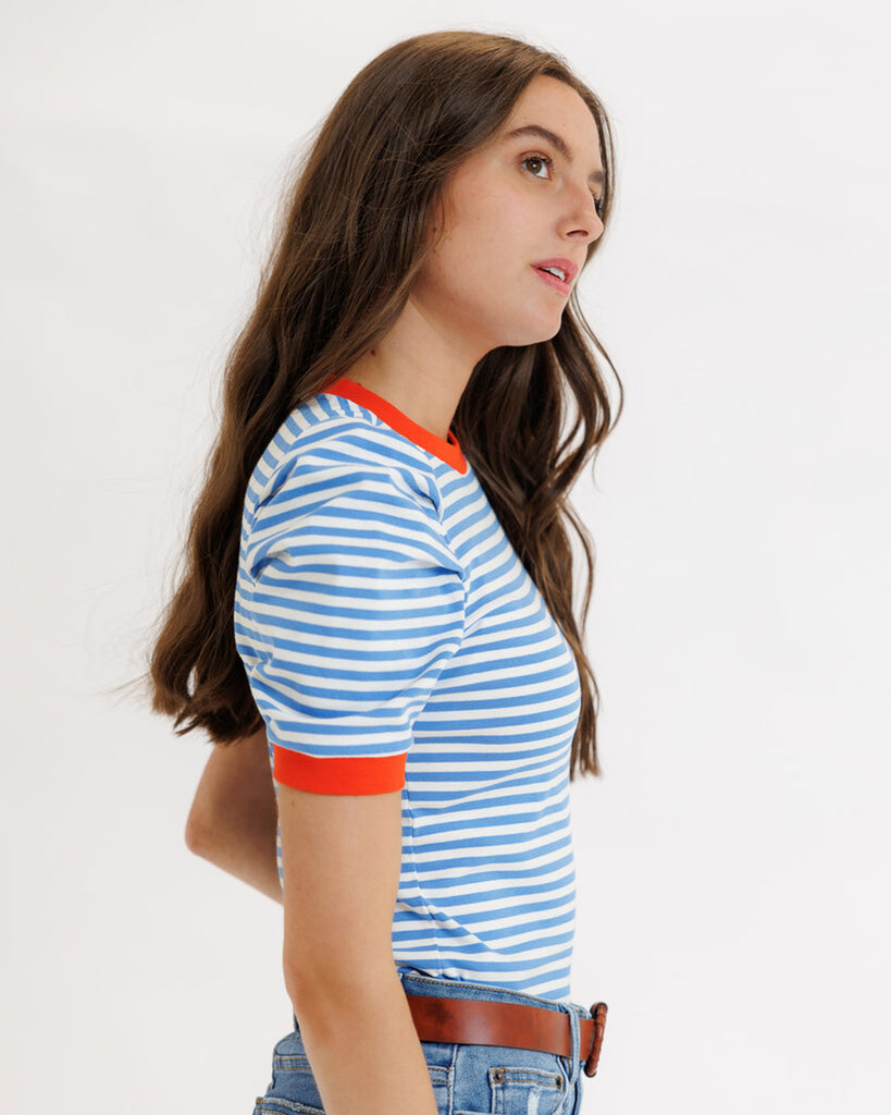 Model wearing a blue striped short sleeve tee with red trim around neckline and arms.