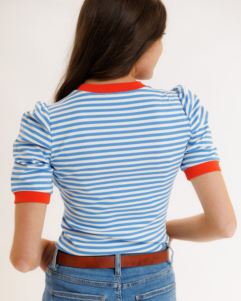 Model wearing a blue striped short sleeve tee with red trim around neckline and arms.