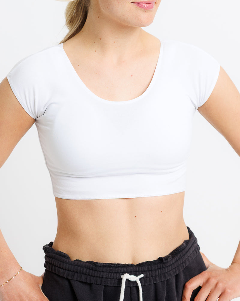 Model wearing a white short sleeve scoop neck cropped tee.