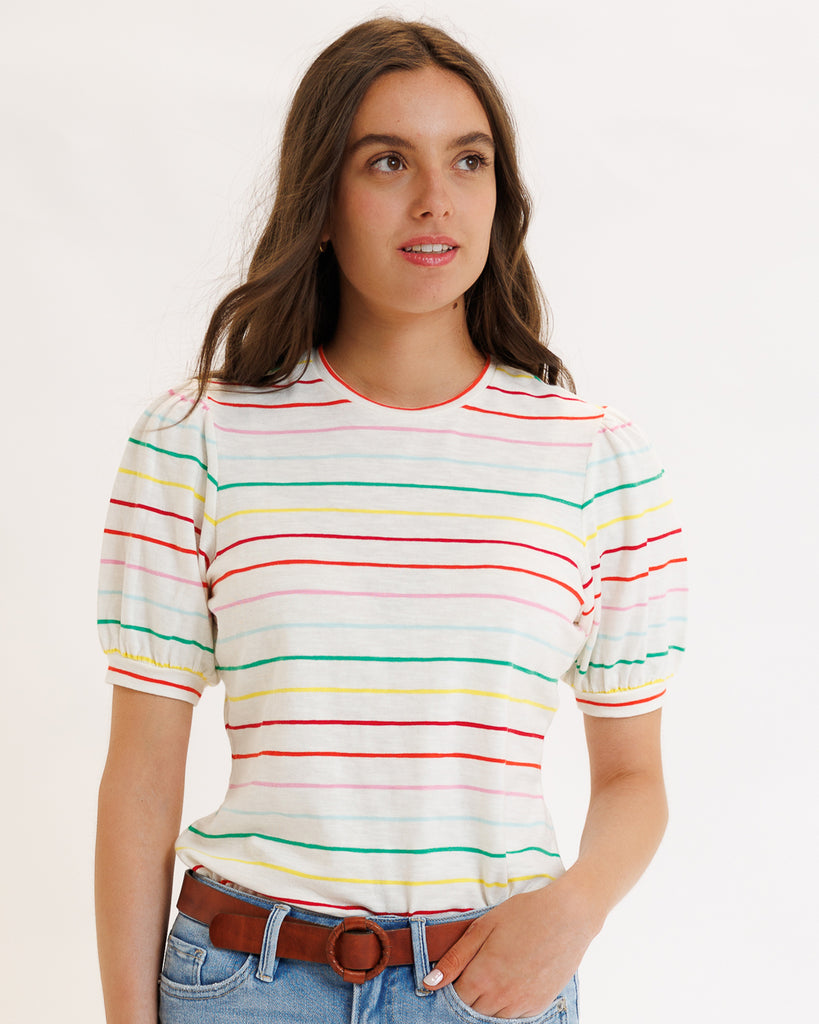 Model wearing a white with rainbow stripes short sleeve t-shirt