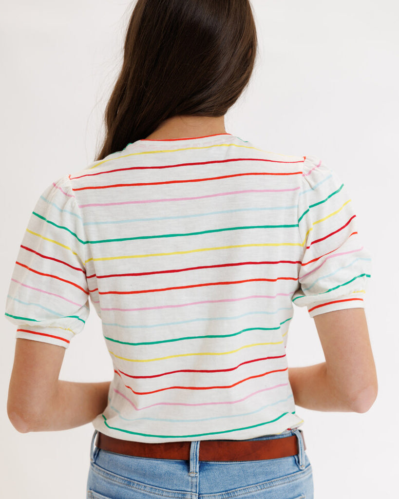 Model wearing a white with rainbow stripes short sleeve t-shirt
