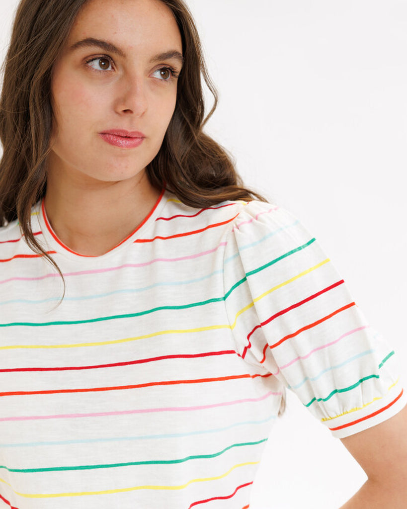 Model wearing a white with rainbow stripes short sleeve t-shirt