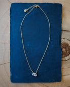 Necklace with a pendant on a blue fabric background