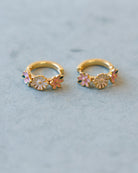 Gold hoop earrings with floral designs on a light blue background