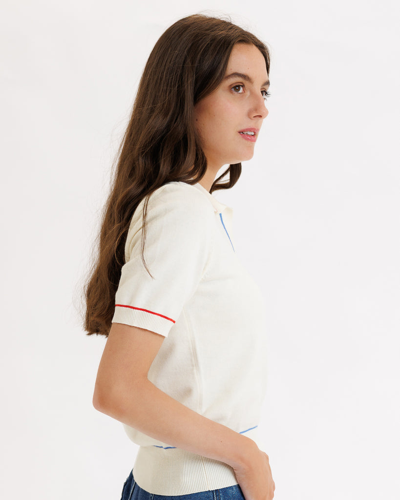 Model wearing a white short sleeve polo sweater