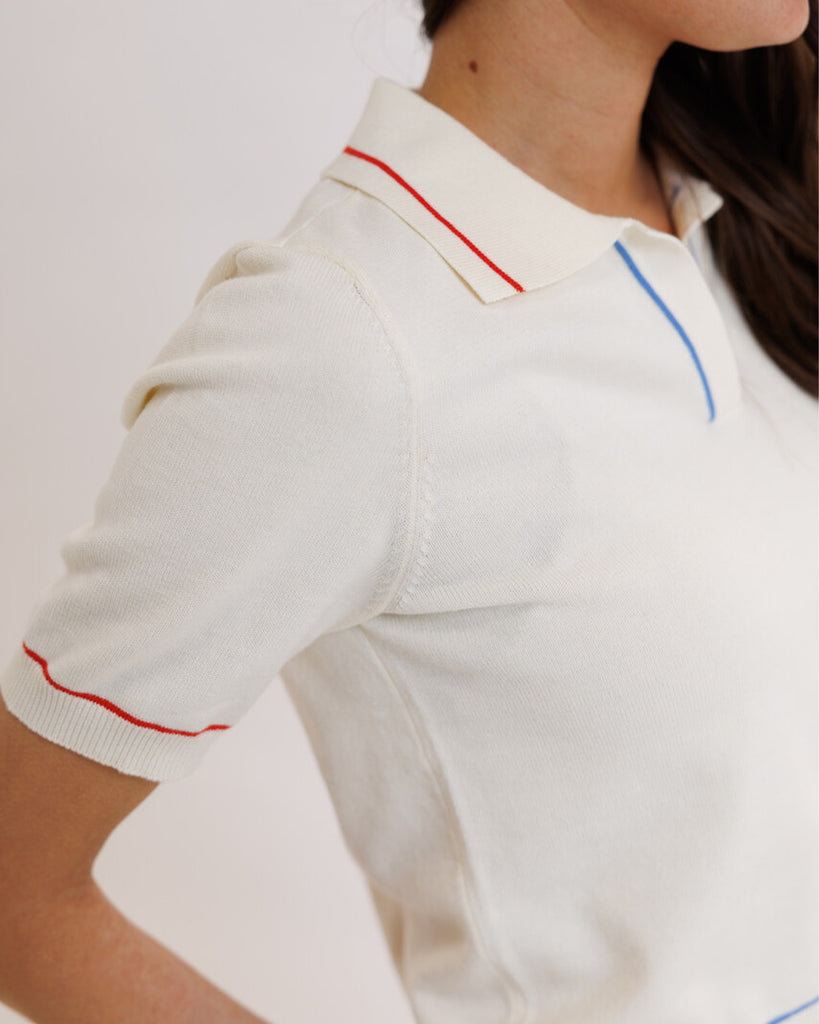 Model wearing a white short sleeve polo sweater