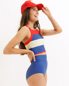 Woman wearing a colorful swimsuit and red cap on a white background