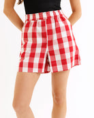 Red and white checkered shorts worn by a person on a white background