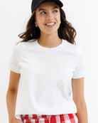 Woman wearing a white t-shirt and red plaid shorts on a white background