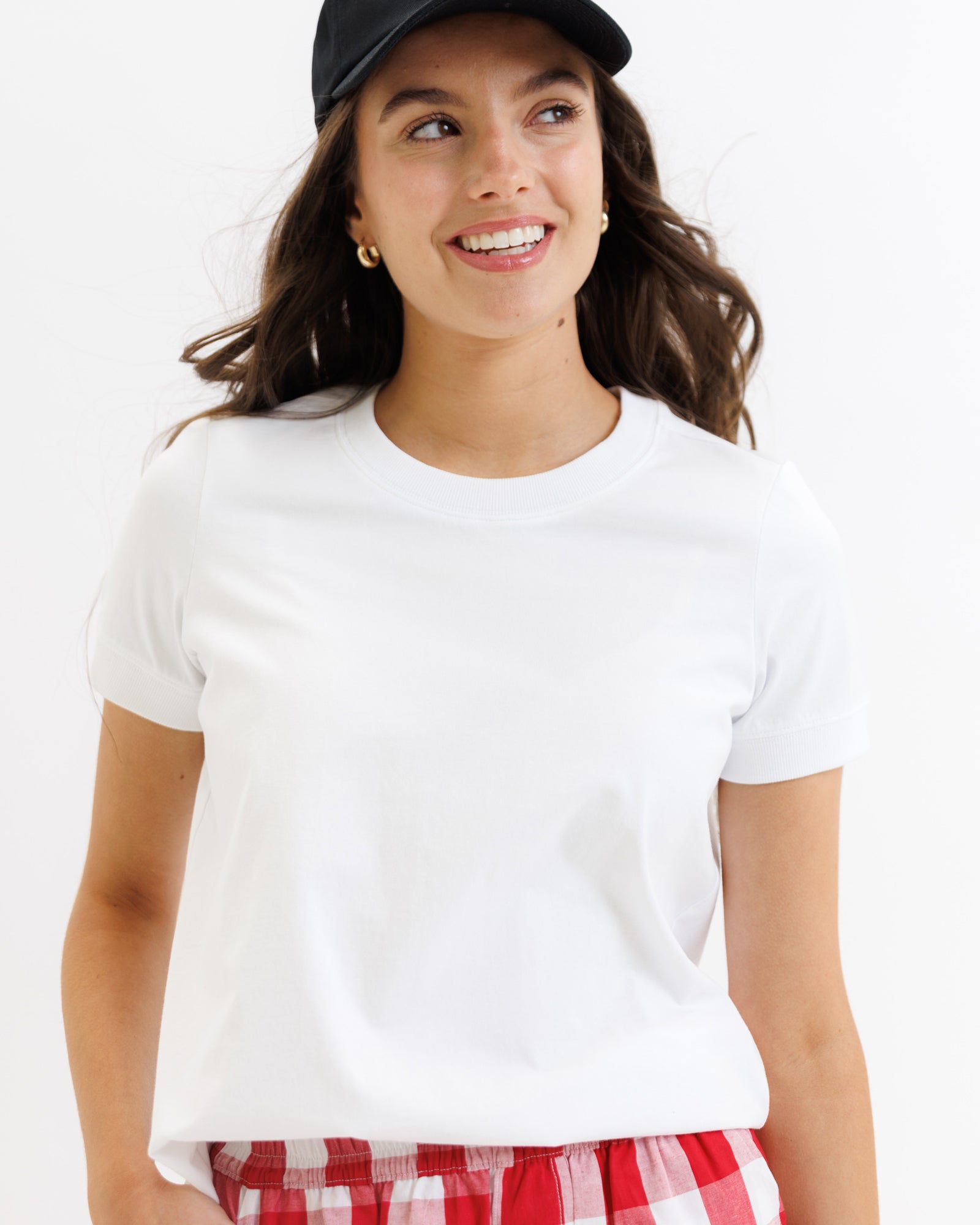 Woman wearing a white t-shirt and red plaid shorts on a white background