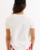 Person wearing a white t-shirt with a red and blue design on a plain background