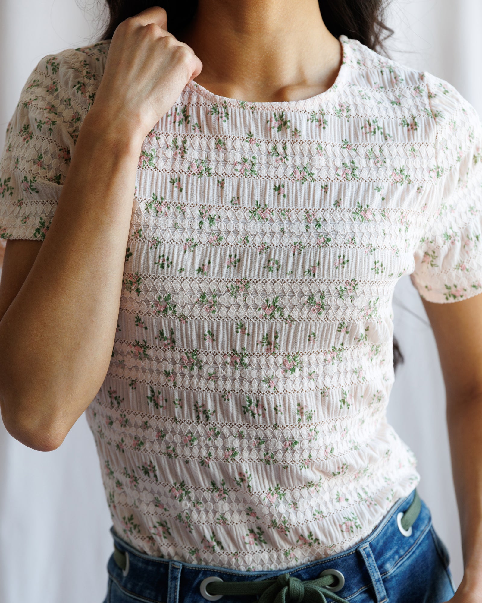 Person wearing a floral patterned top with a blurred background