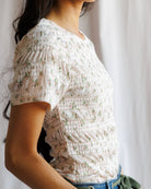 Woman wearing a floral blouse with a blurred background