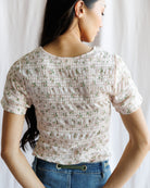 Woman wearing a floral blouse with a plain background