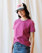 Image of woman wearing a pink short sleeve tshirt in front of a canvas backdrop