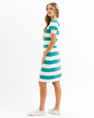 Woman wearing a teal and white striped dress on a white background