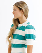 Woman wearing a teal and white striped shirt on a white background
