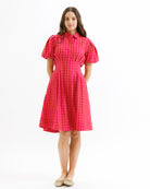 Woman wearing a red checkered dress on a white background