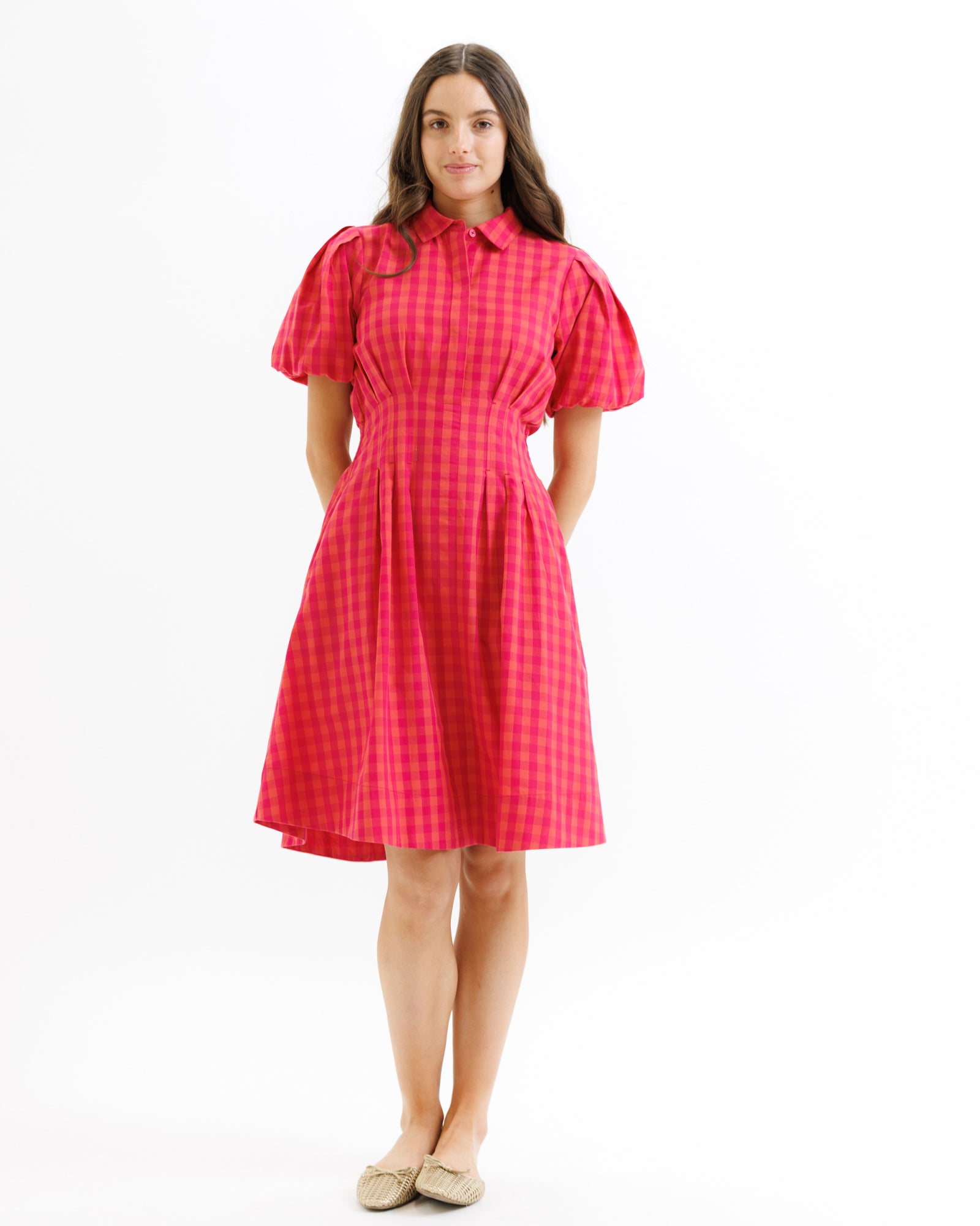 Woman wearing a red checkered dress on a white background