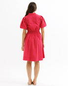 Woman wearing a red checkered dress on a white background