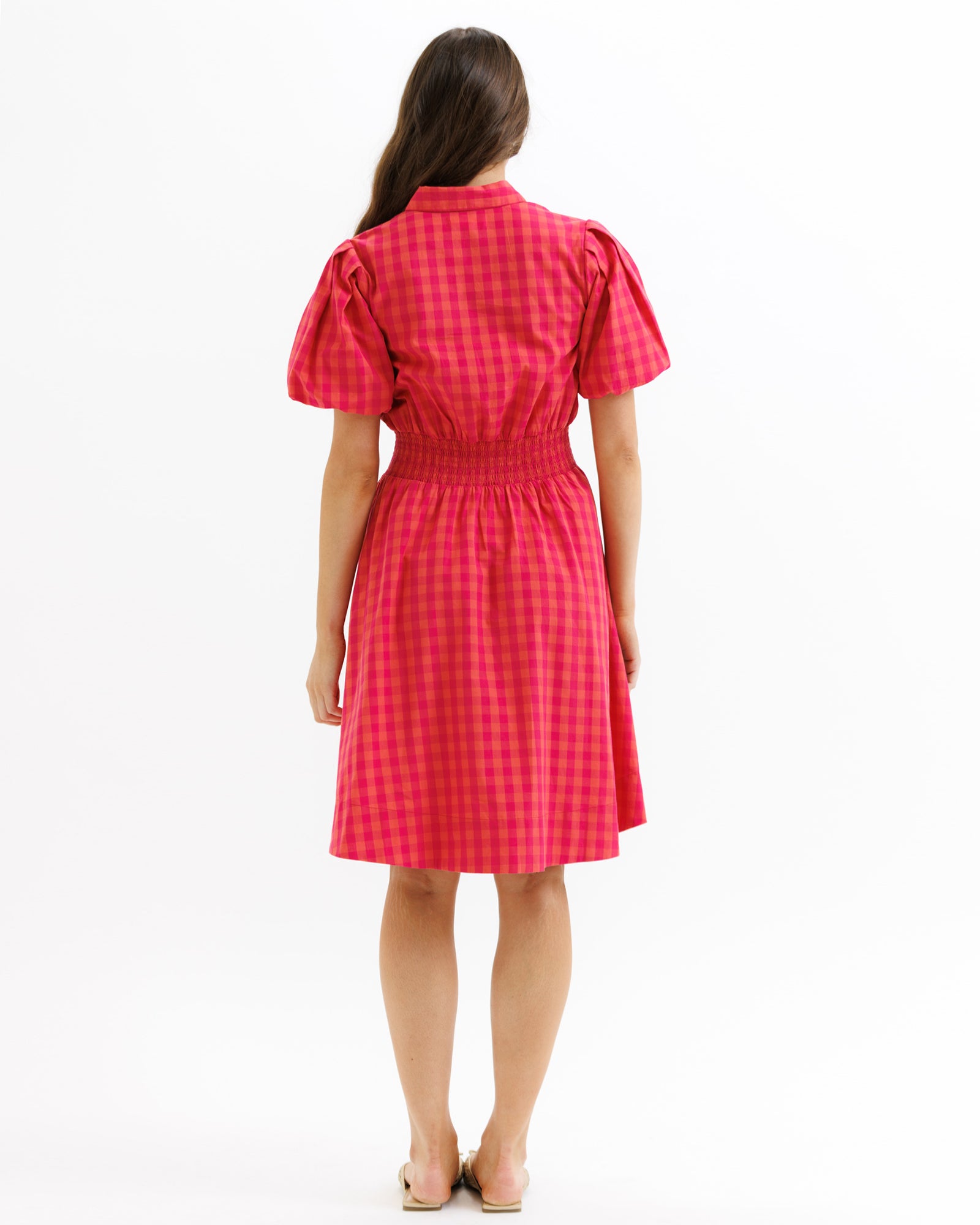 Woman wearing a red checkered dress on a white background