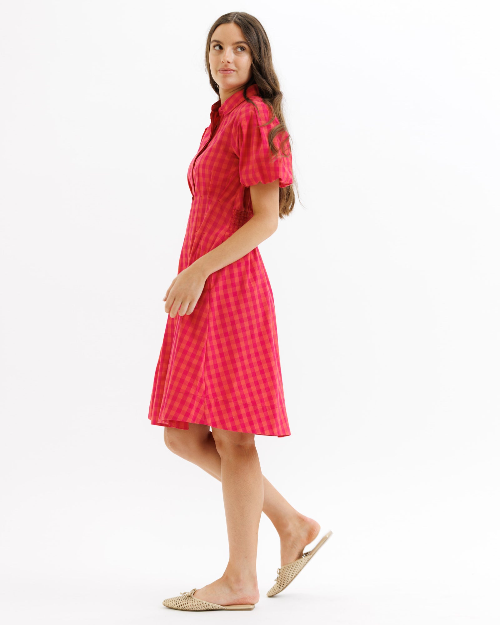Woman wearing a red checkered dress on a white background